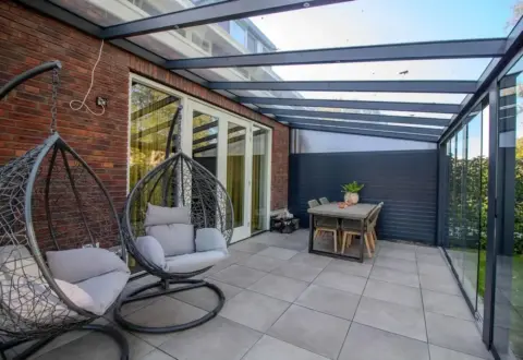 Serre - binnekant Serre - binnenkant met hangstoelen en tafel erin geplaatst
